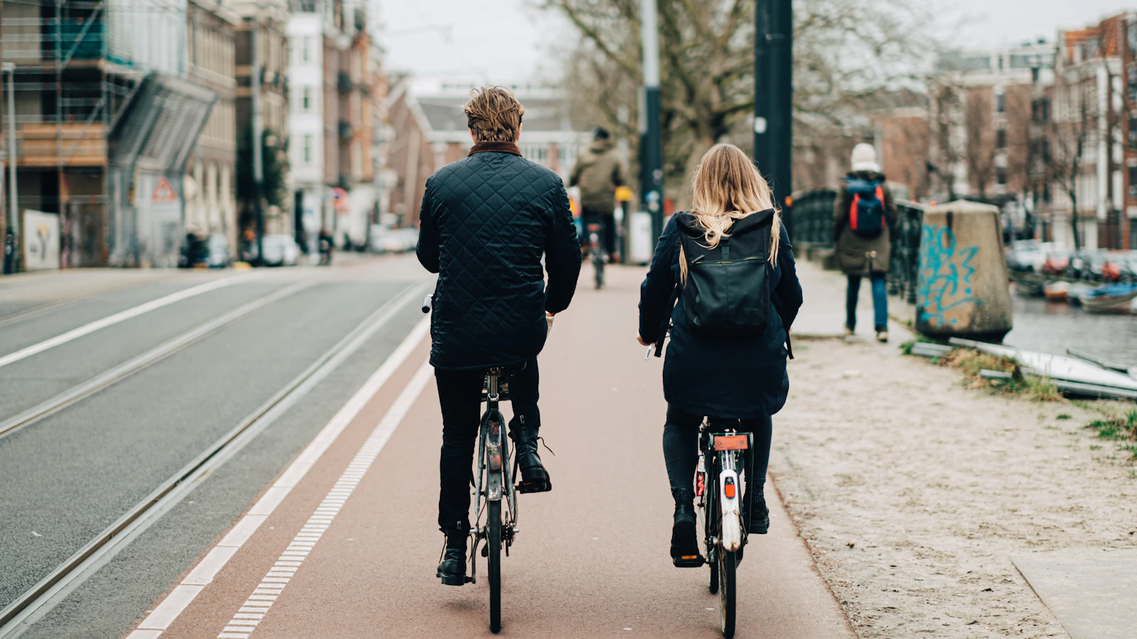 Stel fietst naast elkaar over een fietspad in de stad op een grijze dag.