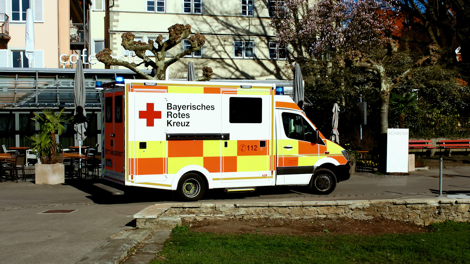 An ambulance parked beside a building during the day.