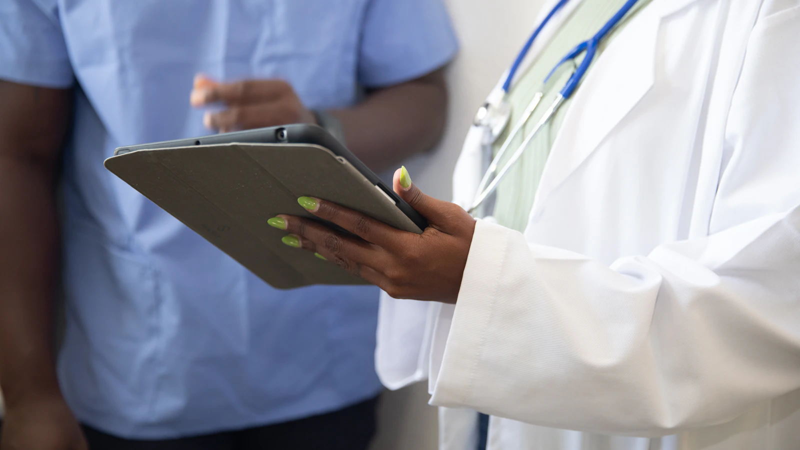 A doctor showing a patient something on a tablet.