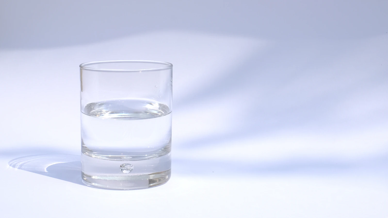 A clear glass of water on a table, as an image of kidney function and hydration.
