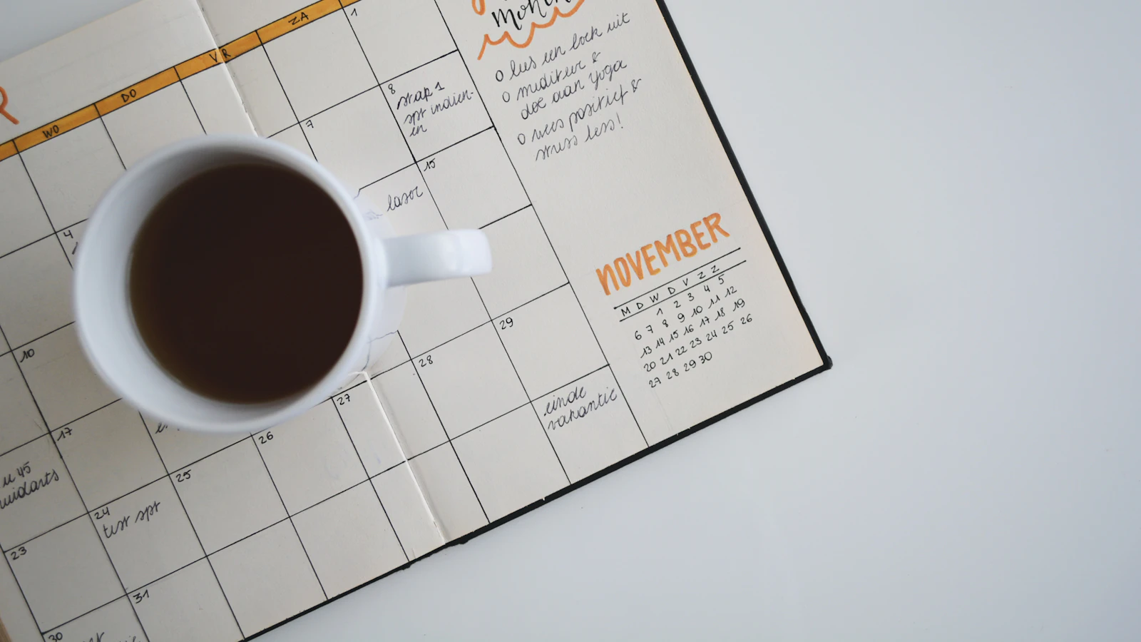 A cup of coffee on a planner, ready to map out a schedule.