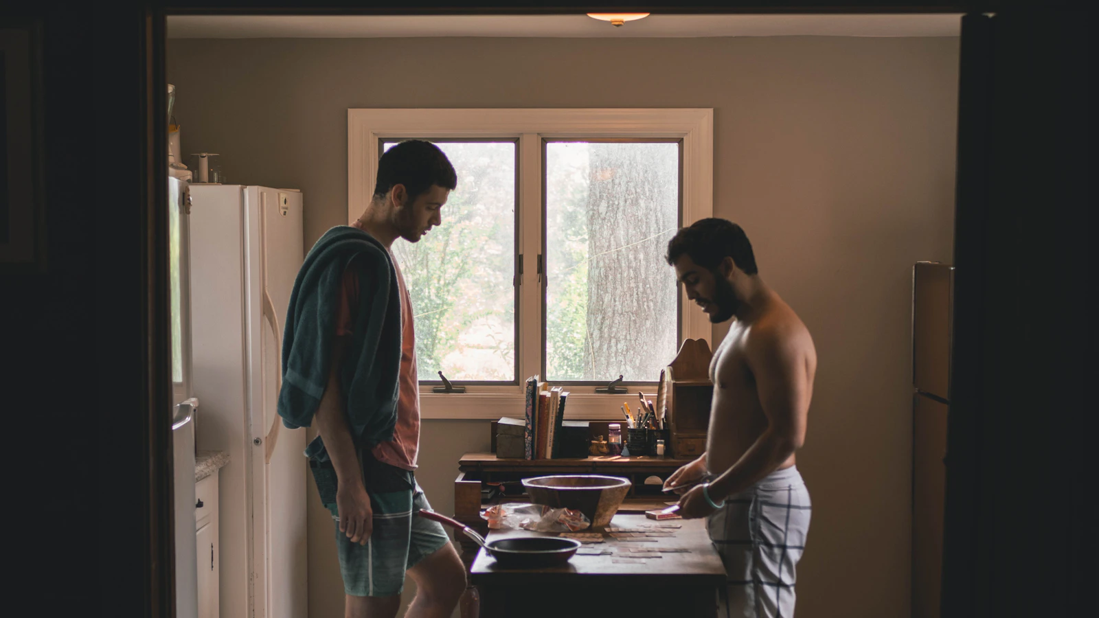 Twee mannen staan rustig samen in een keuken.