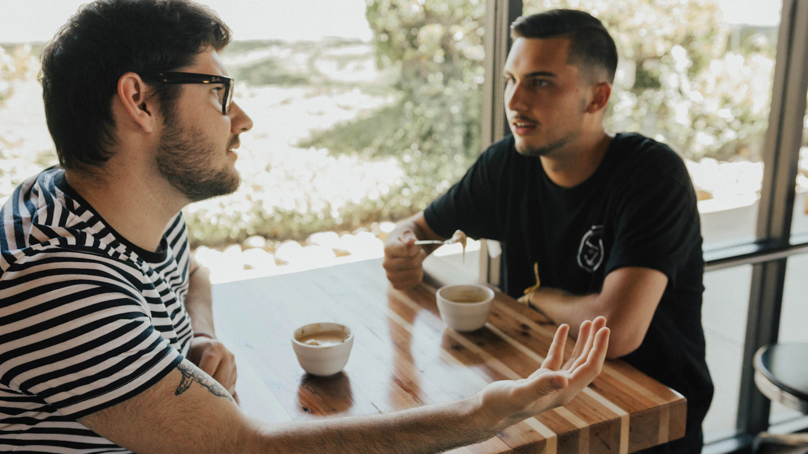 Two men talking calmly with each other at a table.